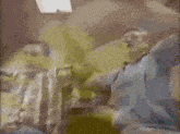 a man in a blue shirt is sitting with his arms up in the air