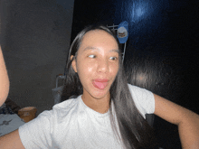 a woman sticking her tongue out while wearing a white shirt that says happy birthday on it