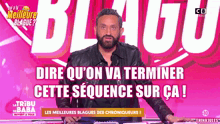 a man with a beard stands in front of a pink background that says blague