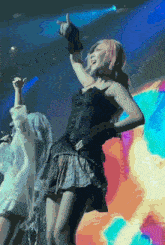 a woman in a black corset and plaid skirt is dancing on stage