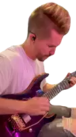 a man in a white shirt is playing a guitar