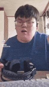 a man wearing glasses and headphones is sitting in front of a computer keyboard
