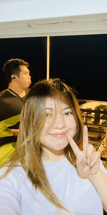 a woman making a peace sign with her finger