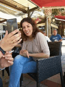 a man wearing a blue shirt that says gant is taking a picture of a woman