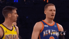 two men in basketball uniforms are standing next to each other on a basketball court .