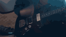 a man is playing a guitar with a fender logo on the headstock