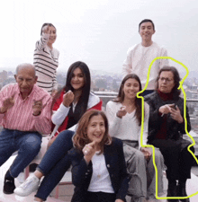 a group of people are posing for a picture and one of them has a yellow outline around her head