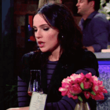 a woman sits at a table with a bottle of joe 's cider