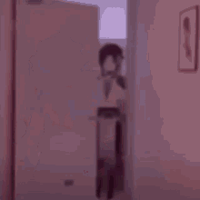 a blurry picture of a person standing in front of a mirror in a hallway .