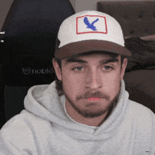 a man with a beard wearing a hat with an eagle on it