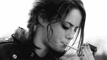 a woman is smoking a cigarette with a lighter .