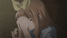 a girl with a bow on her head covering her face