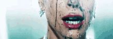 a close up of a woman 's face with red lipstick and water dripping from it .