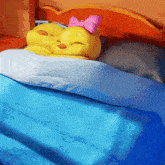 a couple of stuffed chickens sleeping on a bed