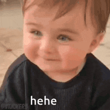 a baby is smiling and making a funny face while laying on the floor .