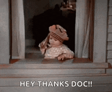 a little girl is looking out of a window and saying hey thanks doc .