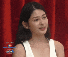 a woman stands in front of a red curtain with the words jenny si brother on it