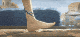 a person 's foot with a bracelet on it