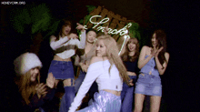 a group of girls are dancing in front of a sign that says snacks