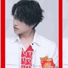 a man in a white jacket is holding a box of pocky sticks