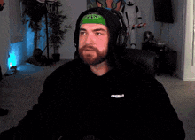 a man wearing headphones and a black hoodie with the word original on the front