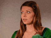 a woman in a green dress with a flower in her hair