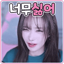 a girl with korean writing on her face is smiling and looking at the camera .