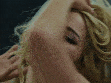 a close up of a blonde woman 's face with her mouth open