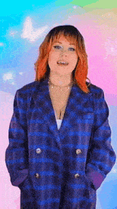a woman with red hair is wearing a blue plaid jacket and a necklace .