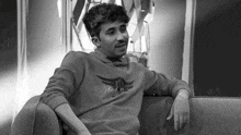 a black and white photo of a man wearing a sweatshirt that says " the wings "
