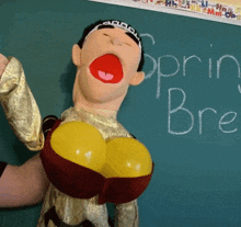 a puppet is standing in front of a chalkboard that says " spring bre "