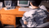 a man is sitting at a desk with a computer and a keyboard .