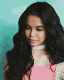 a woman with long black hair wearing a choker and a pink dress .