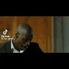 a man in a suit is dancing with his arms outstretched in a room .