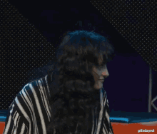 a woman in a black and white striped shirt is smiling