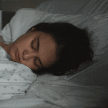 a woman in a hospital gown is sleeping on a bed