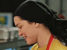 a woman wearing a yellow shirt and a black head scarf