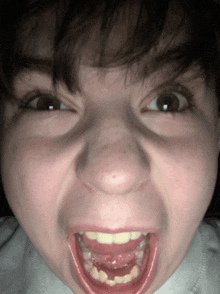 a close up of a person making a funny face with their mouth open