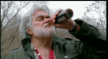 a man with a beard is drinking from a bottle while wearing a green jacket