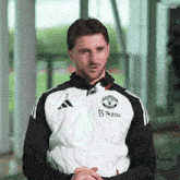 a man wearing a manchester united jacket
