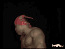 a muscular man wearing a pink bandana on his head is giving a fist bump .