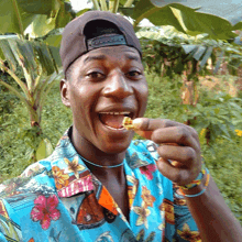 a man wearing a hat and a shirt that says hawaii on it