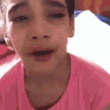 a girl in a pink shirt is making a face