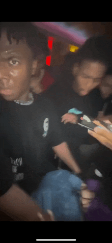 a group of young men are standing in a dark room .