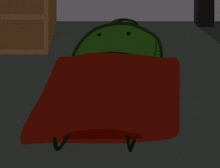 a green frog laying on a red blanket