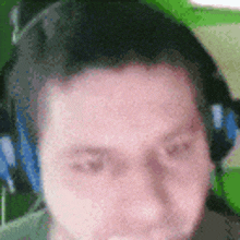 a man wearing headphones is looking at the camera with his eyes closed .