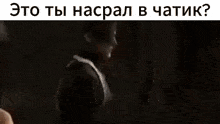 a man is licking another man 's face in a dark room with russian writing .