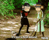 two monkeys are standing next to each other on a dirt path and one says it 's just a flesh wound
