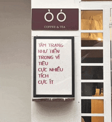 a sign for coffee and tea hangs on a white wall