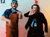 two men wearing headphones and overalls are dancing